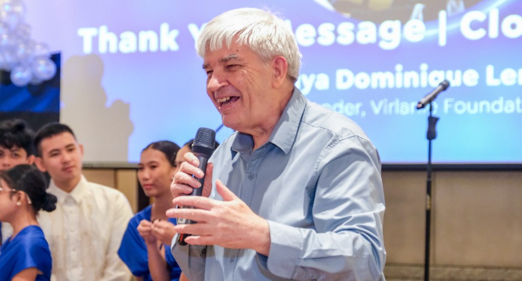A man delivers a speech during an event, standing in front of a group of young people, with a banner in the background that reads 'Thank You Message | Closing.'