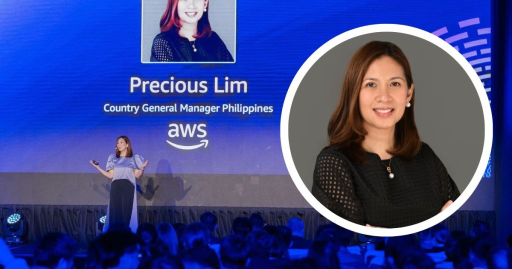 A woman speaking on stage at an event, with a presentation behind her introducing her as Precious Lim, Country General Manager for AWS in the Philippines.