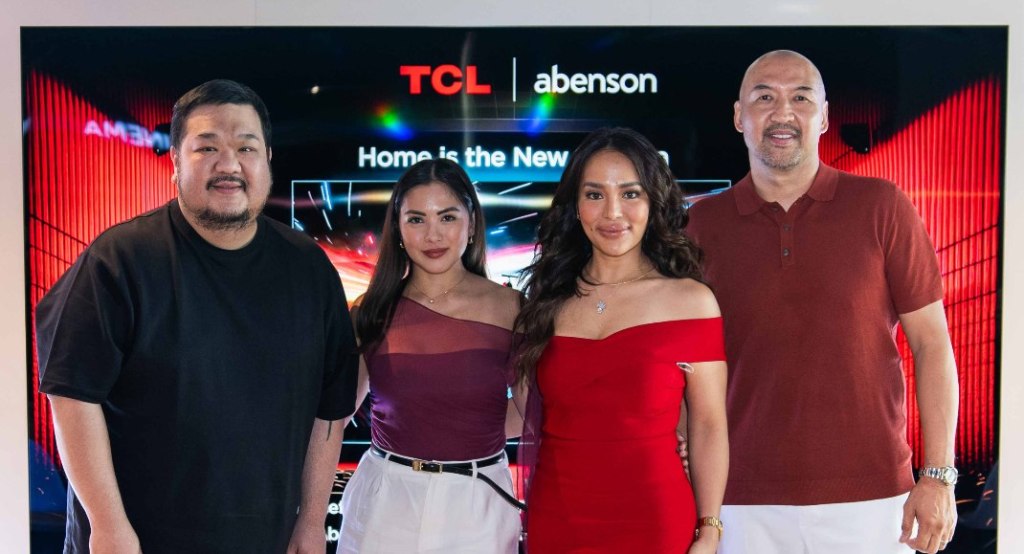 Group of individuals posing in front of a large TCL TV during the launch event.