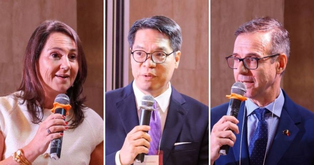 Three speakers at a leadership forum, each holding a microphone, engaged in discussion against a neutral background.