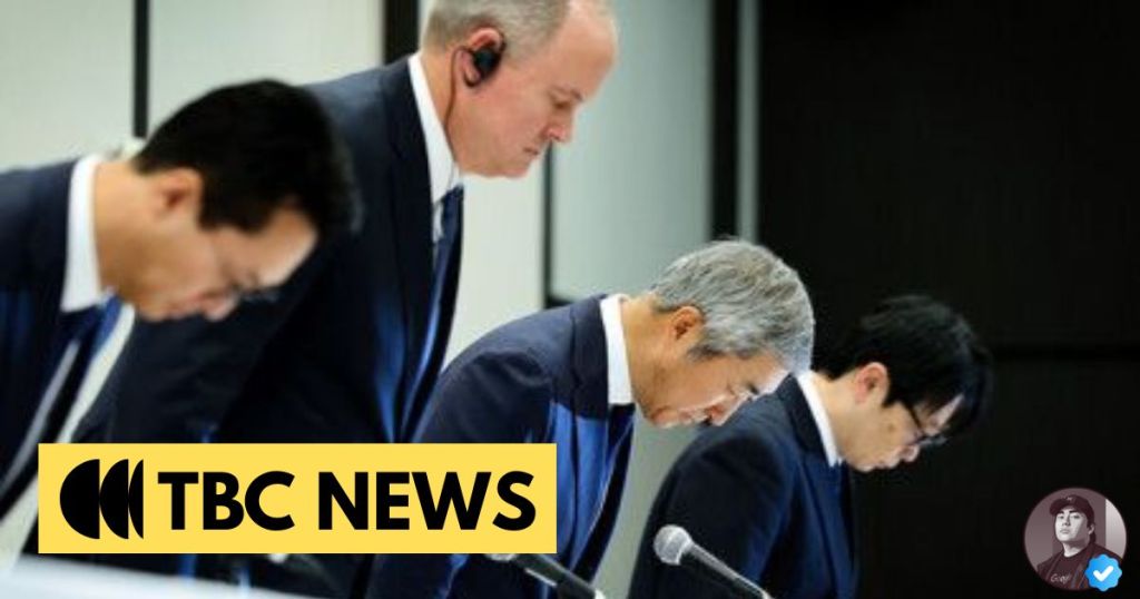 Four men in business attire bowing their heads in a formal setting, conveying a sense of apology or acknowledgment.