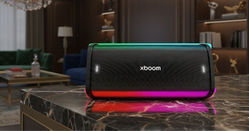 A modern portable speaker with vibrant colored LED lights, placed on a stylish marble table in an elegant living room setting.
