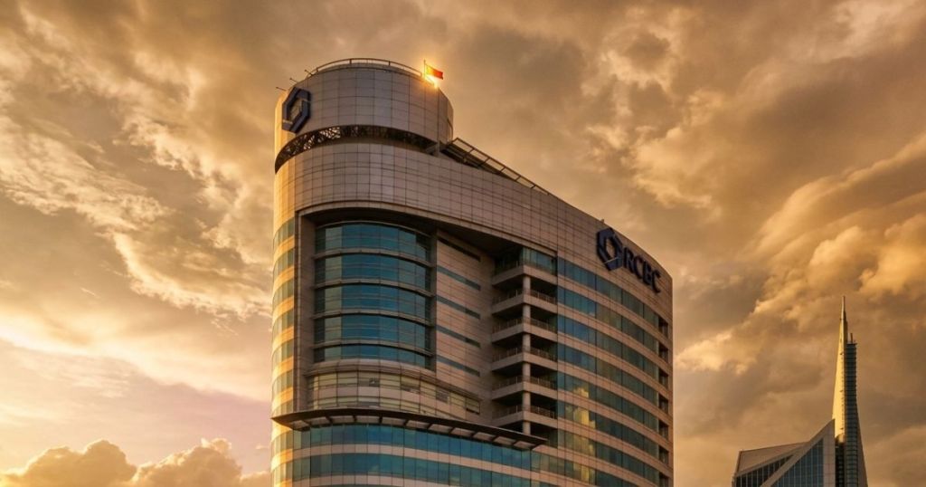 Modern office building featuring large glass windows and a distinctive curved rooftop, set against a dramatic cloudy sky.