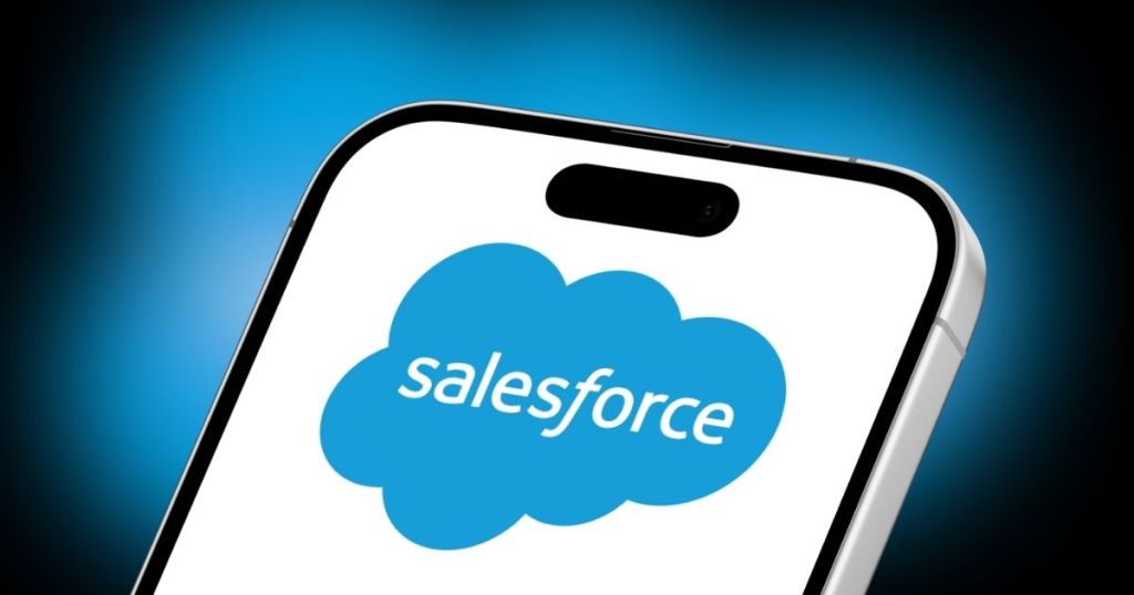 Close-up of a smartphone displaying the Salesforce logo on its screen.