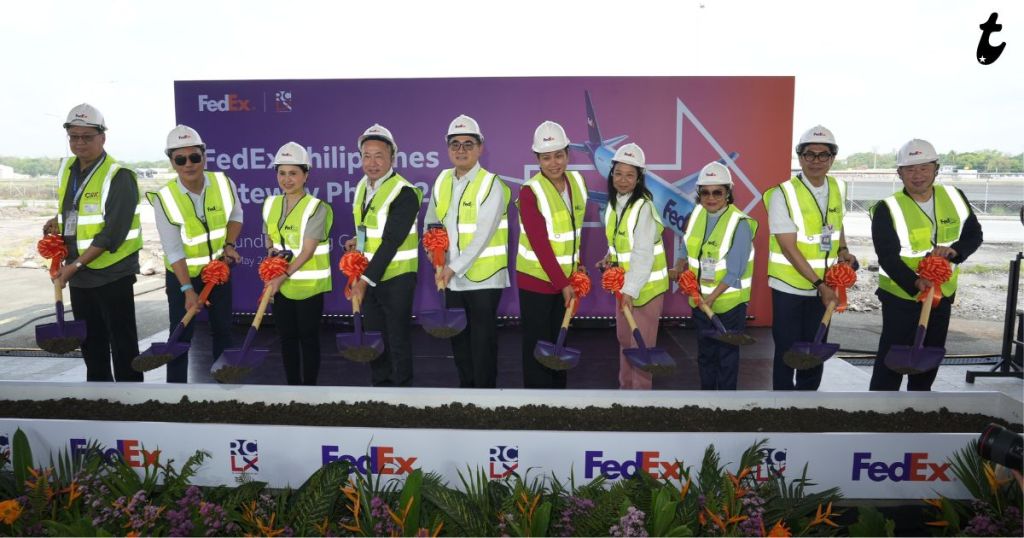 Group of individuals in safety vests and helmets holding shovels during a groundbreaking ceremony for FedEx Philippines' facility, with a branded backdrop.