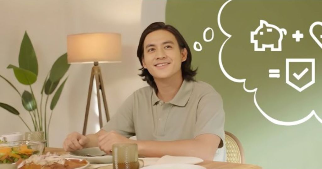 A smiling young man sits at a dining table with a plate of food, looking thoughtful with a graphic of a piggy bank, heart, and checkmark in a thought bubble above him.